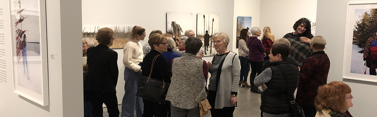 Volunteers view an exhibition at the Judith & Norman Alix Art Gallery